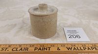 Small lidded pottery jam jar next to a measuring ruler showing approximately 3 inches in height and width.