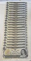 A stack of 20 uncirculated 1973 Canadian one-dollar bills showing front with Queen Elizabeth II and serial numbers.