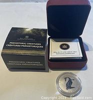 Original lot showing box labeled 'Prehistoric Creatures / Créatures Préhistoriques', open display box with coin and certificate, and coin in protective capsule.
