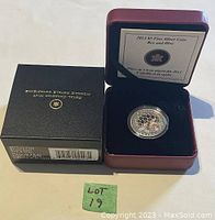 Photo showing the 2013 $3 Fine Silver Coin Bee and Hive in its original red Royal Canadian Mint display box with certificate card inside, alongside the black outer box.
