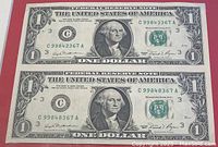 Two uncut 1981 US $1 bills with serial number C99843367A visible front and back