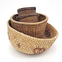 Photo of a lot featuring three vintage woven baskets stacked inside each other, varying in size, shape, and fiber color.