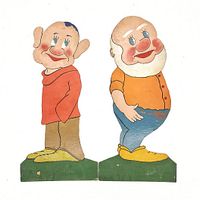 Photo of two vintage Seven Dwarf wooden cutout figures standing on green bases. Both figures show painted faces with rosy cheeks and detailed clothing.