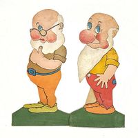 Two vintage cardboard dwarf cutouts standing on green bases showing signs of age-related wear.