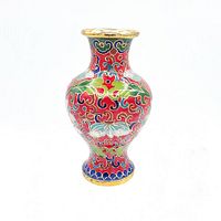 Small vintage cloisonné vase with colorful floral and leaf patterns on a red background, with gold accents on the rim and base, photographed on a white background.