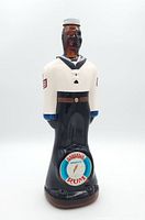 Front view of vintage ceramic bottle shaped like a sailor in uniform, showing label 'Barratt's Double Rum' on front.