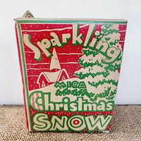 Front and side views of the vintage Sparkling Mega Christmas Snow box showing design and condition.