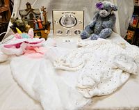 Full lot view with toys, clothes, night light and picture frame arranged on a fabric surface