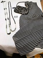 Lot arrangement showing two necklaces, pleated wristlet, and black and white striped scarf.