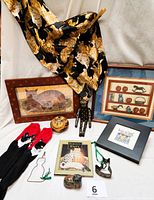Photo showing entire lot on white cloth, includes all items arranged with scarf draped at top left and framed pictures at back