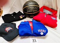 Photo showing all items in the lot including the blue quarter-zip jacket, black polo, black hat, and basketball arranged in front of white backdrop.