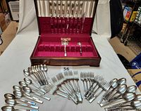 Full set displayed inside and outside the wooden case showing all flatware pieces arranged.