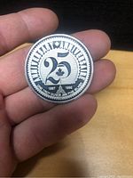 Front side of the silver commemorative coin showing 25th anniversary design and inscriptions.