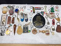 Overview of all vintage key chains spread out on white towel.
