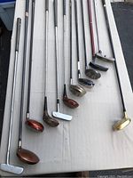 Overview of assorted golf clubs arranged on table