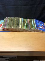 Overview photo showing 35 children's books lined up side by side with colorful covers and spines, representing a lot of Walt Disney storybooks.