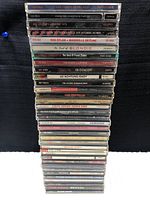 Stack of 34 rock CD jewel cases showing spines with artist and album titles including Dire Straits, Steely Dan, Joe Cocker, U2, and Bob Dylan.