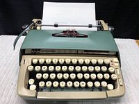 Overall front view showing green top cover, beige body, and sheet of paper inserted