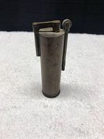 Front view of vintage WW2 copper trench lighter showing cylindrical body and striker wheel with hinged flint cover.