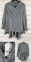 Front view of grey plaid/check long sleeve button-up top with asymmetrical hem hanging on a hanger.