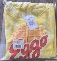 Folded yellow Justice brand girls hoodie in original plastic packaging showing Kellogg's Eggo logo on front.