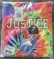 Folded multicolor tie-dye hoodie with 'JUSTICE' and Toucan Sam graphic visible under clear packaging.
