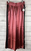 Front view of slate rose wide leg pants with black side panels hung on hanger. Shows gathered waistband with drawstring and smooth sheen fabric.