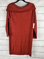 Full view of the red knit sweater dress hanging on black hanger, showing length, wide ribbed collar, and straight silhouette.