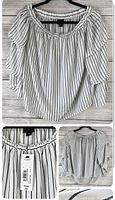 Front view of Worthington black and white vertical striped blouse with layered sleeves on hanger against wood background.