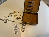 Photo showing multiple pairs of cufflinks, one necklace with pendant, and the leather jewelry case partially open