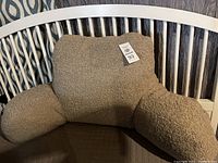 Front view of the beige sherpa back rest pillow showing its size and arm supports