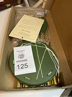 Windchimes in original box with green wooden top, metal tubes, and white cords visible.