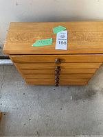 Top view of the wooden drawer unit with tags showing measurements.