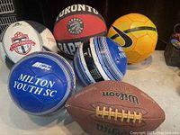 Photo of the five sports balls showing variety in type and brands, including Wilson football, Toronto Raptors basketball, Milton Youth SC volleyballs, and a yellow soccer ball