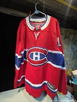 Front view of the red Montreal Canadiens jersey with Canadiens logo and number 13.