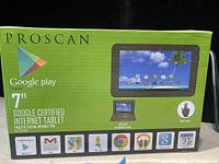Front of green retail box shows Proscan brand logo, Google Play certified, 7-inch screen, included keyboard and case, multi-touch feature, and several Google apps installed.