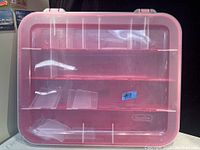 Red plastic Sterilite adjustable ornament storage case with clear lid showing internal adjustable compartments.