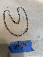 Sterling silver chain laid flat on surface showing full length and general condition.