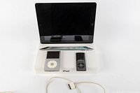 Front view of iPad 2 with screen off, iPod Classic white and iPod Nano black placed in front of it on an iPad stand.