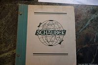 Front cover of Schaubek world stamp album showing globe logo, binding, and overall condition