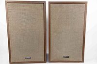 Pair of Advent Model 9 vintage stereo speakers front view showing beige fabric grills and Advent metal logo.