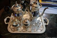 Top view of the vintage silverplate tea set on a silver serving tray showing teapot, coffee pot, cream, sugar containers, salt and pepper shakers, and cutting tool rests.