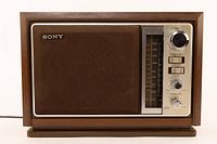 Full front view of vintage Sony AM/FM table radio showing speaker grille and control panel with tuning dial and knobs.
