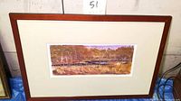 Framed landscape monotype print showing scenic marshes with autumn colors, wood frame and off-white matting.