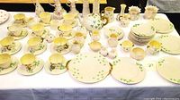 Wide view of teacup and saucer pairs with matching plates on display