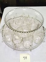 Top view showing the punch bowl, platter, and 16 mugs arranged inside the platter.