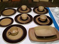 Franciscan Discovery stoneware dinner plates, salad plates, teacups, saucers, and serving dishes arranged on a white surface.