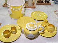 Overview of tea set components including teapot, plates, hexagonal containers, creamer, and ice bucket showing shape, color, and design details.