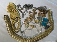 Full lot layout showing multiple necklace and chain items with coin design motifs, pearl-like beads, macrame necklace, and bracelets.