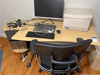View of office desk with side table and black ergonomic chair from behind. Desk has office electronics on top but not included in the lot.